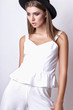 © yuliachupina - Girl in white clothes and black hat posing in studio on white background.