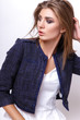 © yuliachupina - Young woman dressed in white clothes and blue jacket posing in studio on a white background