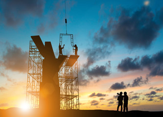 Wall Mural - Silhouette construction industry team safely to work load concrete building according to set goal over blurred background sunset pastel for industry background.