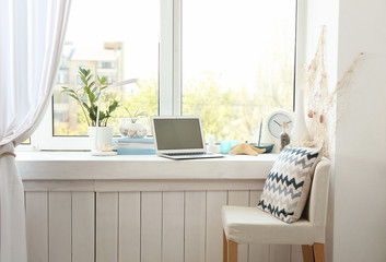 Modern comfortable workplace with laptop on window sill at home