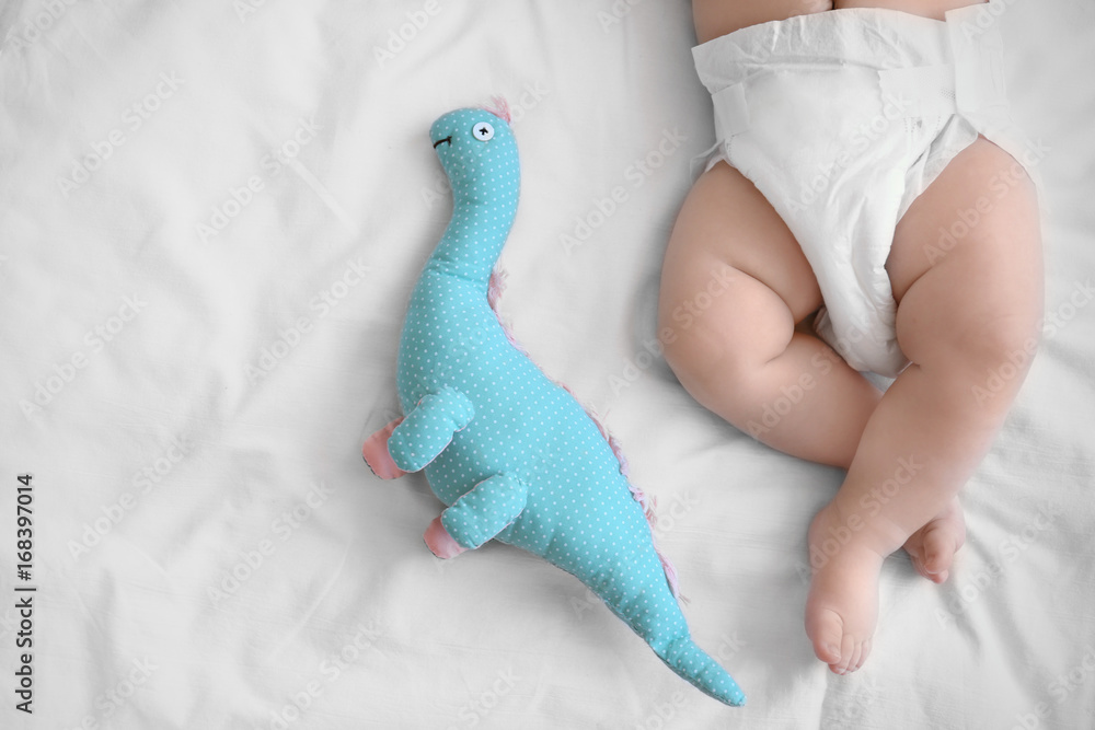 Cute little baby with toy sleeping on bed at home