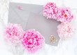 Postal card with envelope and peonies. Top view with copy space