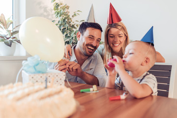 Happy family celebrating little boy's birthday at home.