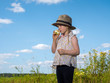 © kozorog - Child in field eating an Apple. Blue sky. The girl in the hat. The concept of the child in the village, travel