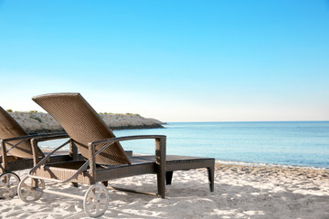 Canvas Print - Empty sunbeds on beach near sea