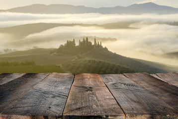 Wall Mural - empty wooden table and Tuscan landscape at sunrise