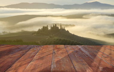 Wall Mural - empty wooden table and Tuscan landscape at sunrise