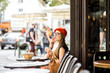 © rh2010 - Young stylish woman in red beret smoking a cigarette sitting outdoors at the french cafe