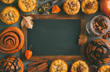 Wall Mural - freshly baked pumpkin muffins and cinnamon rolls with empty chalkboard. autumn menu