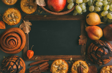 Wall Mural - freshly baked pumpkin muffins and cinnamon rolls with empty chalkboard. top view. autumn menu