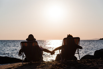 Wall Mural - Couple enjoying sunset at a beach