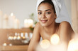 © Cookie Studio - Portrait of beautiful african girl with towel on head smiling resting in spa salon.
