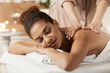 © Cookie Studio - Attractive african girl having massage relaxing in spa salon. Closed eyes.