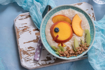 Kids breakfast oatmeal porridge with fruits look like cute fish