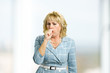 © DenisProduction.com - Mature woman coughing into her hand. Adult woman is coughing because having a flu. Concept of chronic cough.