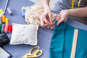 Woman tailor working on a clothing sewing stitching measuring fa