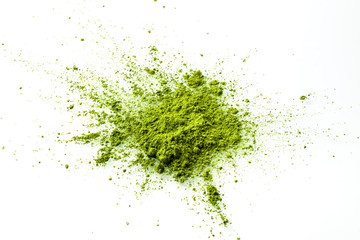 Matcha powder explosion on white background from above. Matcha is made of finely ground green tea powder. It's very common in japanese culture. Matcha is healthy due to it's high antioxydant count.