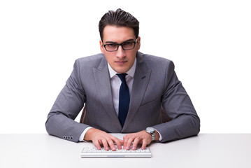 Young businessman typing on a keyboard isolated on white backgro