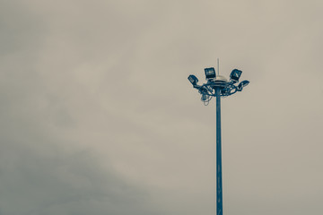 Lamp post electricity industry with blue sky background. Spotlight tower, vintage tone.