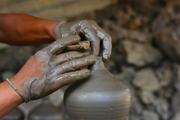 close up on hands making pots on pottery wheel