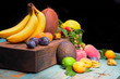 Fruit bunch with coconut, Mango, peaches, apricots, lemons, physalis, plums on the colorful wood background