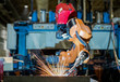 Industrial robot is welding automotive part in factory