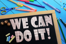 The Text We Can Do It On A Black Chalkboard On The Table With School Accessories (pens, Pencils, Brushes)