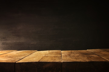 Wall Mural - wooden table and blackboard background. Ready for product display montage