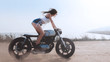 © supamotion - Sexy female in protective mask riding fast on her custom built cafe racer motorcycle in the desert
