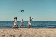 © LIGHTFIELD STUDIOS - father and kids playing with kite on beach