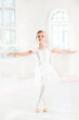© master1305 - Little ballerina girl in a tutu. Adorable child dancing classical ballet in a white studio.