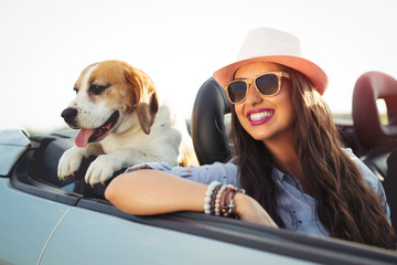 Woman and dog in car on summer travel