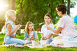 © pressmaster - Kindergarten teacher shaming little girls during picnic or outdoor party in park