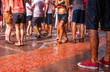 Tłum ludzi bawiących się na La Tomatina. Ujęcie nóg. 