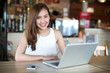 © uinmine - Young Asia woman sitting at cafe working on laptop and smart phone