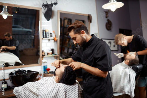 Fényképezés  Barber working with client in chair