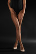 © Africa Studio - Legs of beautiful young woman in tights on dark background