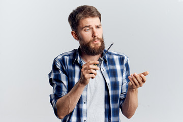 Man with a beard on a light background holds a screwdriver, construction tools, repair