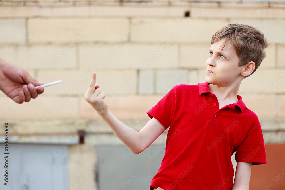 Photo Stock Boy showing middle finger refusing the proposed cigarette. Bad  habits, healthcare, stop smoking concept