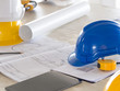 © Nattakorn - safety helmet for engineer and architect on working desk/table with drawing/blueprint and tools at job site, engineer/architect for construction work concept