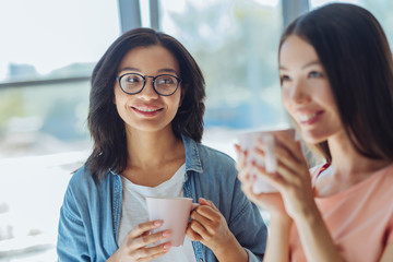 Wall Mural - Cheerful pleasant woman looking at her friend