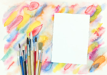 Wall Mural - empty paper sheet with various paintbrushes over colorful diagonal watercolor strokes background