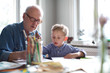 © NIMA Stock - grandfather helping grandson with homework. concentration, kindergarten teacher, glasses, study.