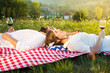 © creativefamily - Couple lying on a picnic blanket with glass of wine