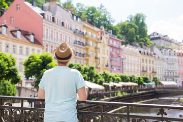 Wall Mural - Back view of happy stylish tourist on Czech Republic. Handsome man travelling in Europe.