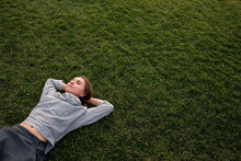 Beautiful Young European Woman Lays Down On Grass And Rests