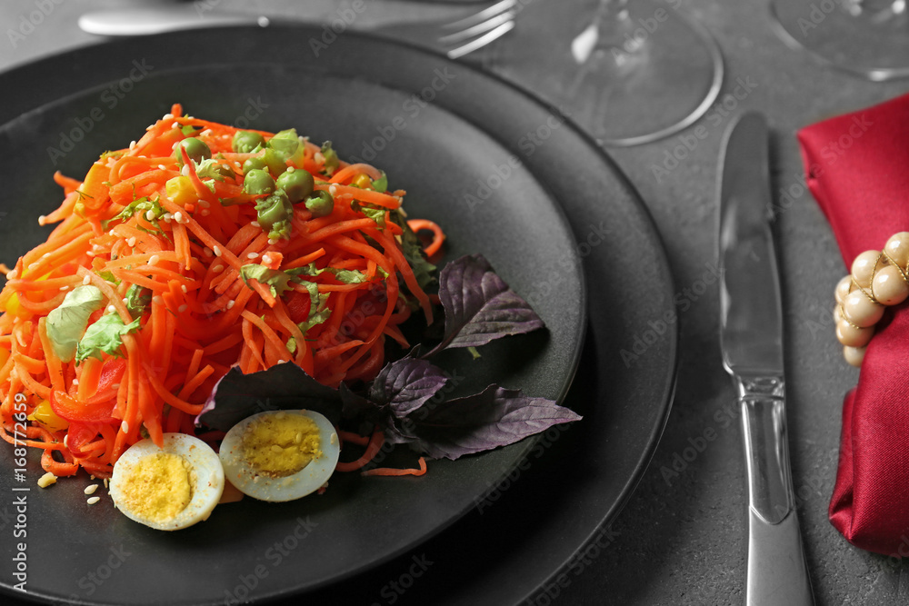 Plate with delicious spicy carrot spaghetti on table