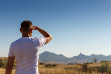 A Man Looking Into The Distance To The Mountains