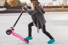 Blond Little Girl With A Pink Push Scooter