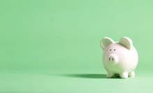White Piggy Bank With Glasses On A Muted Green Background